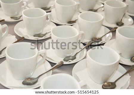 Many white coffee cups in a line.
