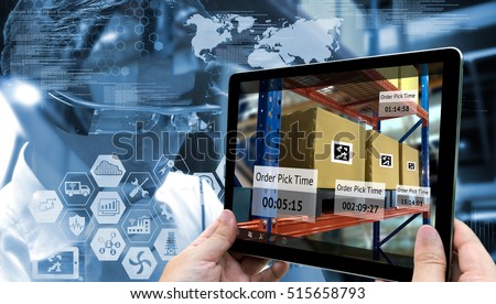 Industry 4.0,Augmented reality and smart logistic concept. Hand holding tablet with AR application for check order pick time in smart factory warehouse.Man use AR glasses and infographic background. Royalty-Free Stock Photo #515658793