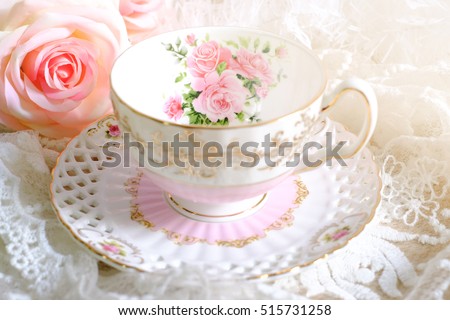 Lovely teacup on white table wiith pink rose