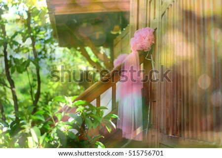 Pink flower ball on the stair with abstract blur and green tree bokeh background