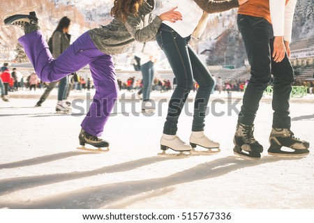 Funny teenagers girls and boy skating outdoor, ice rink Royalty-Free Stock Photo #515767336