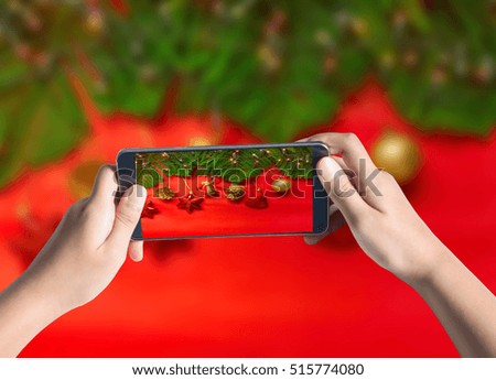 Taking photo of Christmas tree with lights on red background.