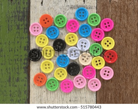 Clothes buttons on vintage wooden texture background with copyspace