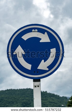 Blue roundabout traffic sign on cloud background