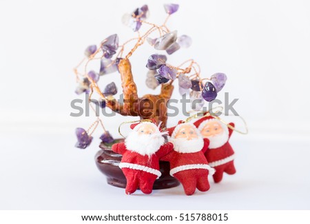 Three Santa Claus and Christmas tree with leaves of amethyst