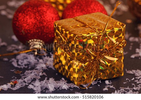 Gold box with gifts. On black background