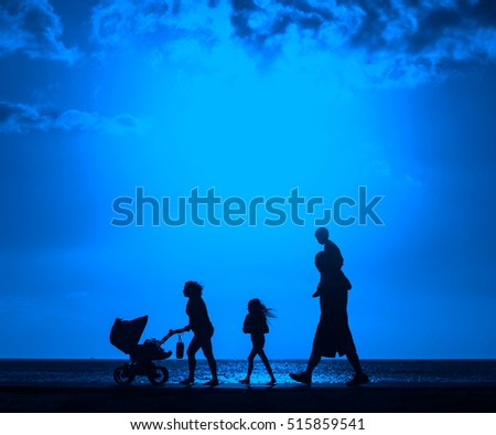 Silhouette of family walking on the beach with mother pushing baby cart   with color filter effected