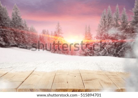 Wooden desk of snow and free place for your decoration with background of mountains landscape, big trees, sunset time and pink winter sky. Photo for advertising use. 