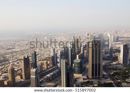 Aerial view of downtown Dubai showing commercial buildings and a dusty skyline