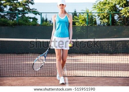 Young woman tennis player. full length front portrait. on court