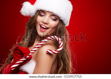 Happy smiling woman in santa claus christmas costume looking up on red background with empty copy space.