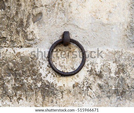 Big stained metal ring on the wall. Tuscany, Italy.