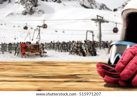 Background with free space for your product. Fuzzy gloves and ski helmet in the right corner. Ski station on the glacier. 