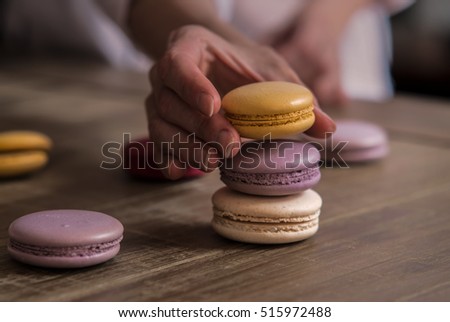 Close up of female pastry chef's hand cooking delicious macaroon. Close up, selective focus.