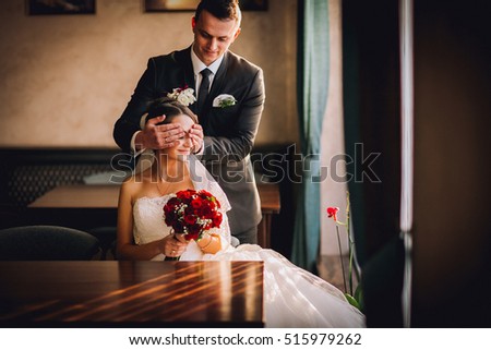 luxury wedding couple holding hands and sitting in cafe in morning near window in soft light. elegant gorgeous bride and stylish groom in retro style. romantic moment