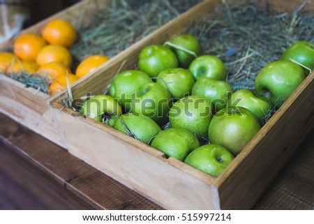 Wooden box with fresh green apples on display in a fruit shop