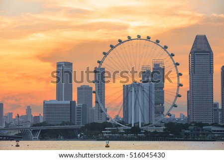 view of central Singapore with Flyer observation wheel and water on foreground. Modern city architecture at sunset Royalty-Free Stock Photo #516045430