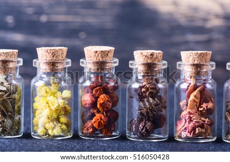 Nature medicine . Herbs in bottles on wooden background .