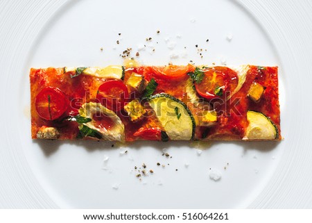Gourmet ratatouille pizza slice on white plate