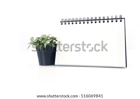 Desktop Loop wire binding book and nerve plant on isolated white background.