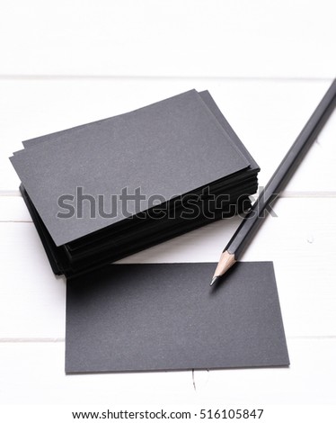 black business cards with pencil on a white table