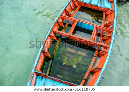 old boat full of water and seaweeds