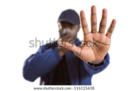 Confident security talking on walkie talkie and making hand stop gesture against white background
