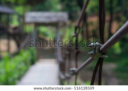 suspension bridge in the forest,Bridge with wires,Suspension bridge, Crossing the river, ferriage in the woods,Hanging bridge. Suspension bridge, bridge through the forest.canal across a river  Royalty-Free Stock Photo #516128509