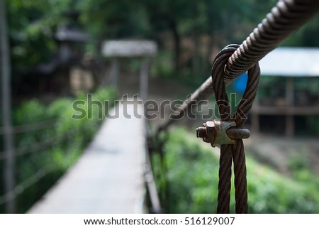 suspension bridge in the forest,Bridge with wires,Suspension bridge, Crossing the river, ferriage in the woods,Hanging bridge. Suspension bridge, bridge through the forest.canal across a river  Royalty-Free Stock Photo #516129007