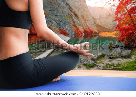 woman meditating on wood floor with Scenic view of lake and fall trees, yoga concept.