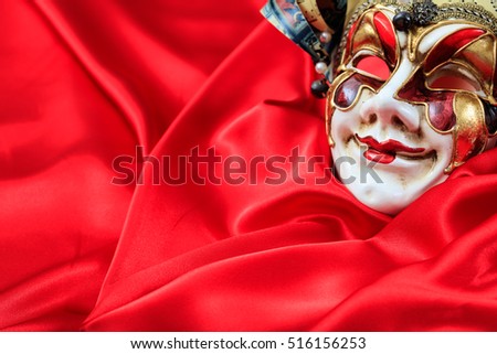 Harlequin carnival mask isolated on red satin background