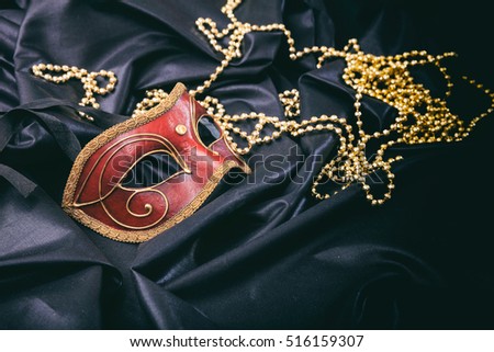 Red carnival mask isolated on black satin background