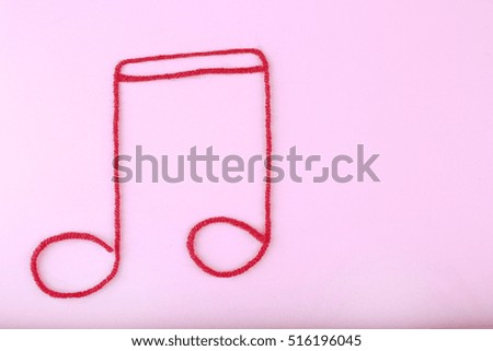 Music note sign made of rope on purple background