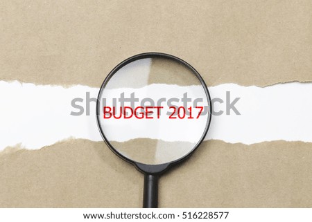 Budget 2017 word written under torn paper with magnifying glass