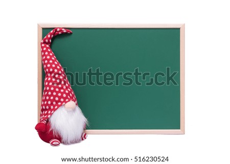 Christmas Elf With Long White Beard Sitting Beside an Empty Green Chalkboard on a White Background