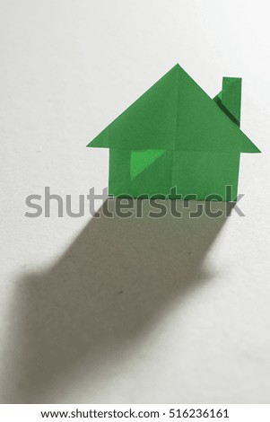House figure origami over white paper