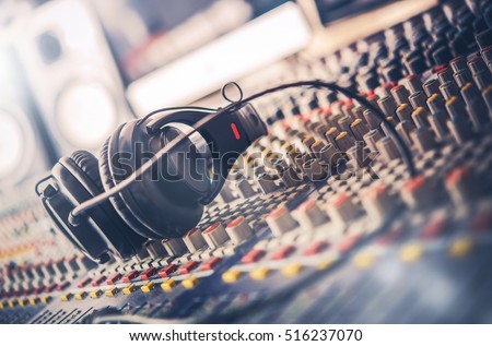 Mixer and Professional Headphones in the Recording Studio. Sound Mixing Desk. Sound Mastering For Radio and TV Broadcast.