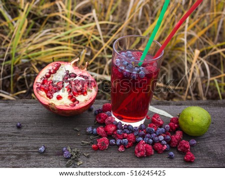 A glass of pomegranate juice with fresh pomegranate fruits on wooden table.  Vitamins and minerals. Healthy drink concept. background of meadows