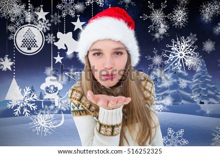 Portrait of beautiful woman in santa claus costume blowing a kiss against digitally generated background