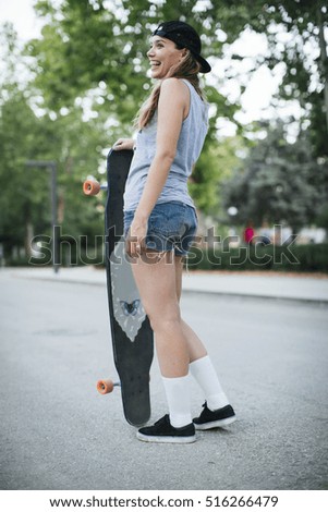 Young woman riding on her longboard.