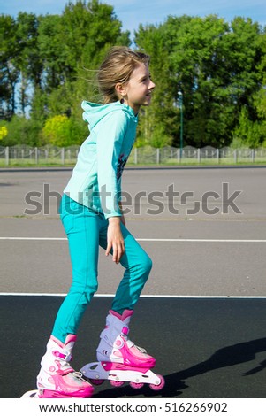 The little girl rides roller skates. Rest. Fitness.