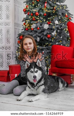 Girl child with dog near a Christmas Tree. Christmas photo