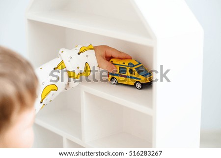 Adorable kid boy playing with cars and toys at home, indoor.