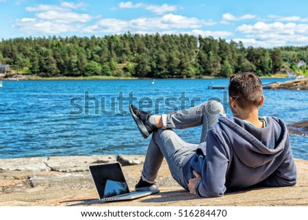 Freelancer man with laptop on colorful beach of island