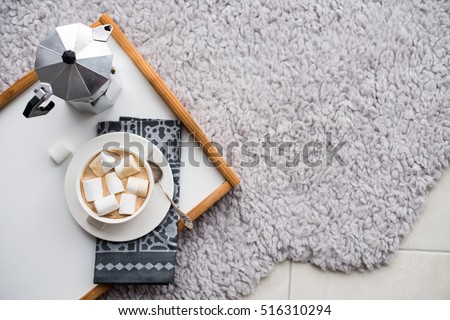 Warm cozy home. Tray and cup of coffee with marshmallows  Royalty-Free Stock Photo #516310294