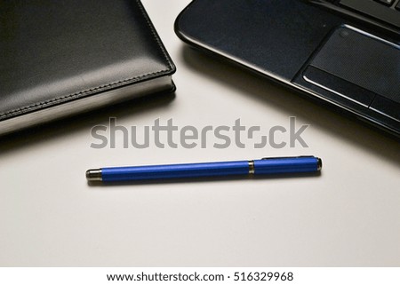 laptop, notebook and pen lying on the desktop. business style