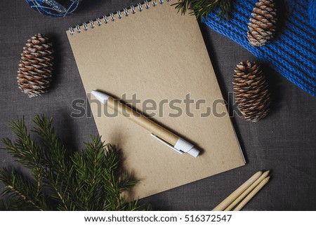 view of notebook in the center of cute blue Christmas decoration, cones