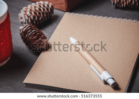 view of notebook in the center of cute red Christmas decoration, cones