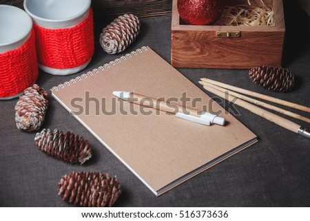 view of notebook in the center of cute red Christmas decoration, cones