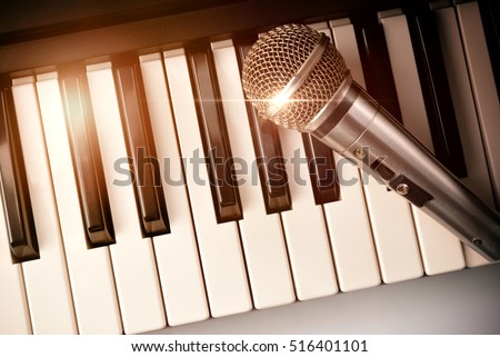 Piano and microphone with golden sparkles. Horizontal Composition.Top view